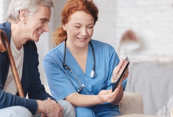 nurse showing tablet to senior patient