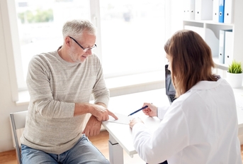 senior man with doctor discussing prescription