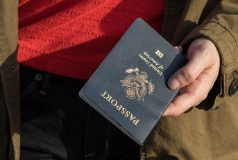 woman wearing coat holding passport