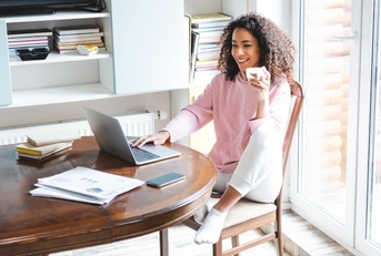 holding cup with using laptop