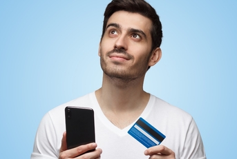 man holding smartphone and credit card