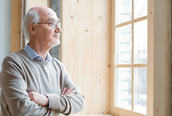 senior man gazing through window