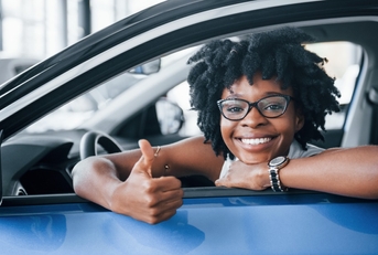excited african american woman in car