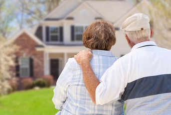 retired couple sitting outside new house