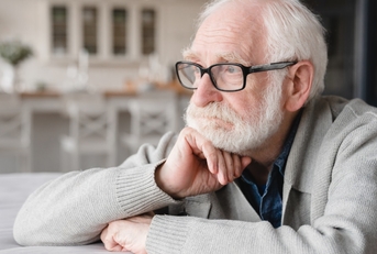 depressed senior man sitting on couch 