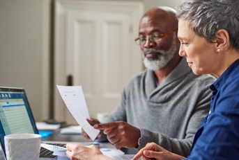 multi ethnic senior couple reviewing taxes