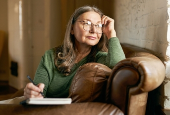 retired female in stylish round glasses
