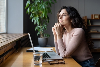 woman thinking about goals at desk