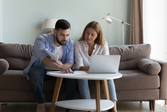 Young Couple reviewing bills at home 