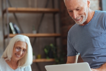 senior couple sorting finances using laptop