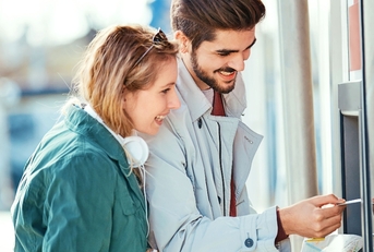 Couple taking money out of an ATM