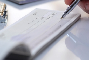 man signing cheque
