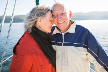 smiling senior couple on sailboat