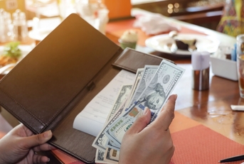 woman keeping tips in bill book