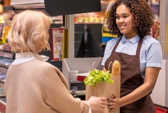 female cashier giving client groceries