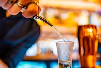 bartender pouring alcohol in shot glass