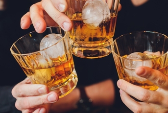 friends clinking alcohol glasses at party