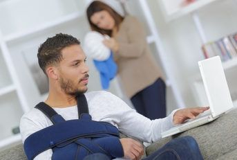 man with arm injury using laptop