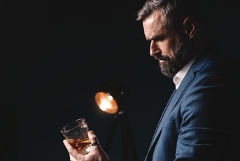 man holds glass of brandy