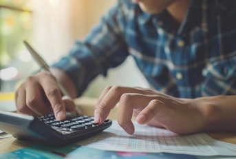 man reviewing bills using calculator