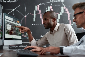 male brokers reviewing stocks together