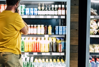 man besides drinks refrigerator