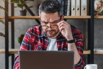 confused businessman looking at laptop screen