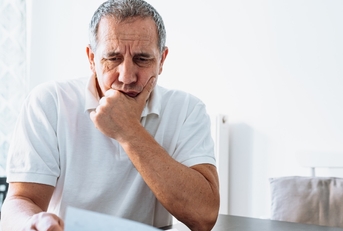 senior man reviewing bills at home