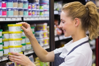blonde worker keeping products in shelf
