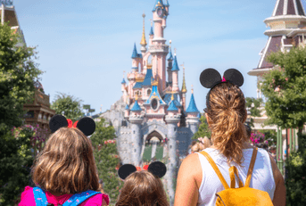 A family stands in front of the Princess Castle at Disney. 