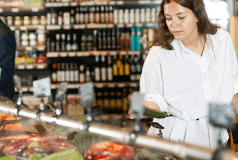 woman looking at vegetables in grocery store