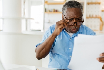 amazed pensioner looking at bills