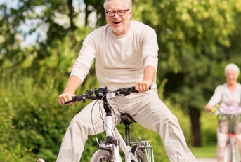 senior couple riding bicycles at park