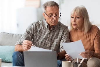 senior couple reading bills at home