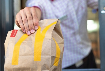 McDonald's worker holding fast food bag