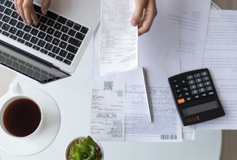 woman reviewing bills on laptop