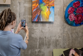 woman photographing painting