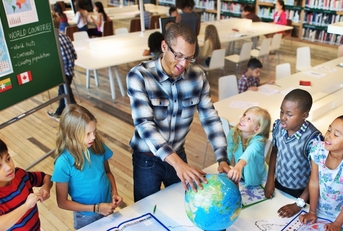geography teacher teaching students in classroom