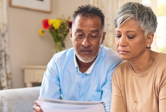 senior couple reviewing bills using laptop