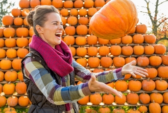 happy woman throwing pumpkin