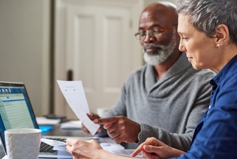 retired couple reviewing monthly budget 