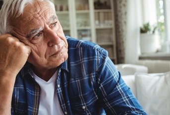 Worried senior man sitting on a sofa