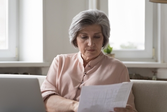senior female accountant checking paper invoices