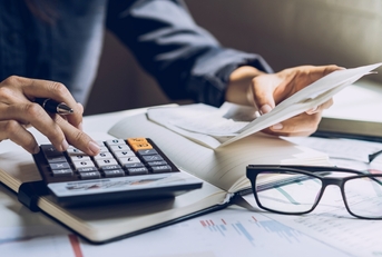 stressed man reviewing bills using calculator