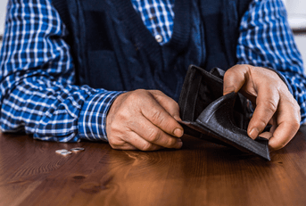 senior man showing an empty wallet without money