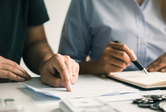 men and women together analyzing expenses 