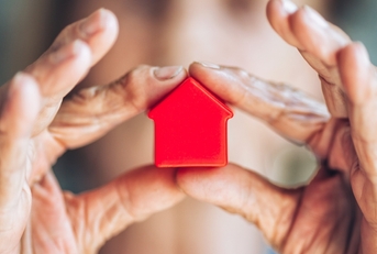 woman holding miniature house sculpture property concept