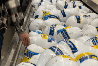 shopper is choosing a turkey in grocery store