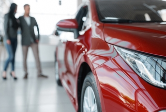 Couple buying new red car