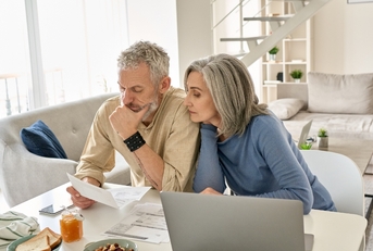 Retired couple reviewing bills together at home 